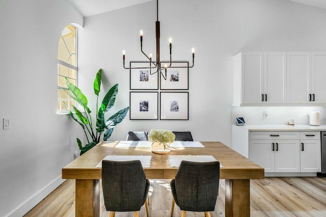 dining space featuring light wood-style floors, baseboards, and a chandelier