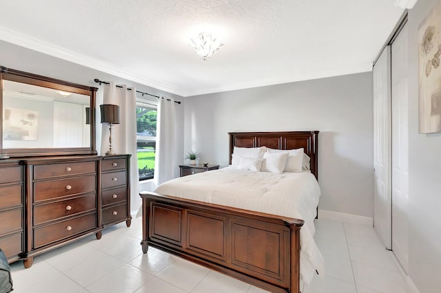 bedroom with crown molding, light tile patterned flooring, and baseboards