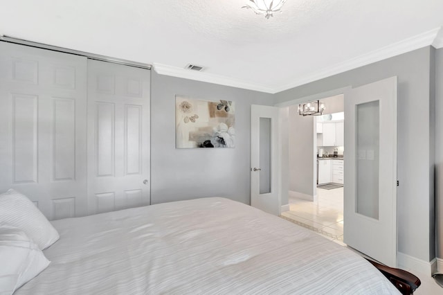 bedroom featuring crown molding, baseboards, visible vents, and a closet