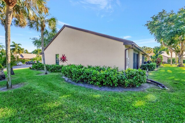 view of side of home featuring a yard and stucco siding