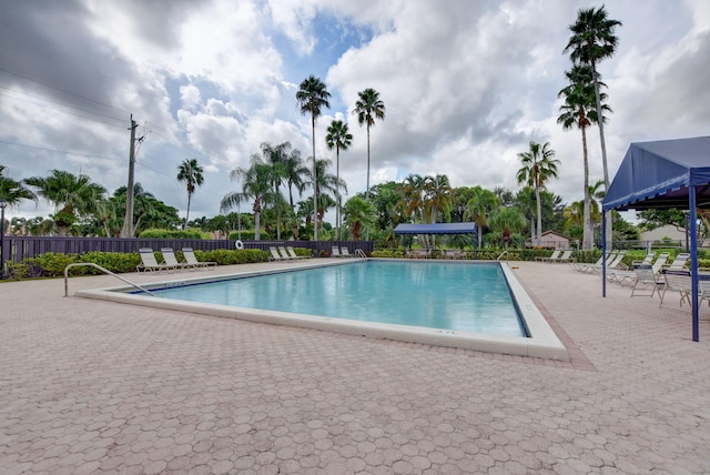 pool with a patio and fence