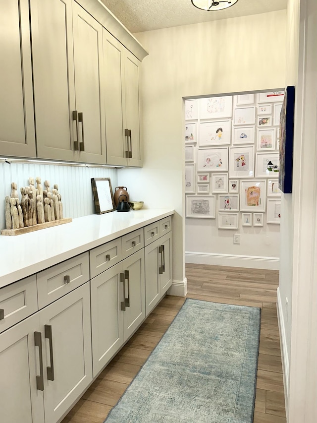 interior space with light wood finished floors, light countertops, and baseboards