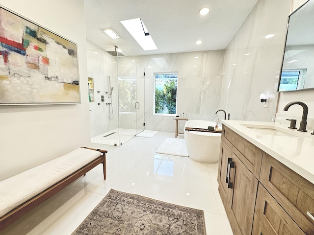 full bath featuring a marble finish shower, a skylight, tile patterned flooring, a soaking tub, and vanity