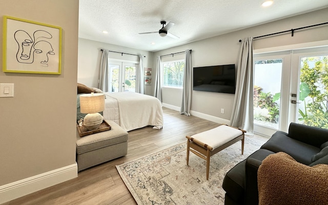 bedroom with access to outside, wood finished floors, french doors, and a textured ceiling