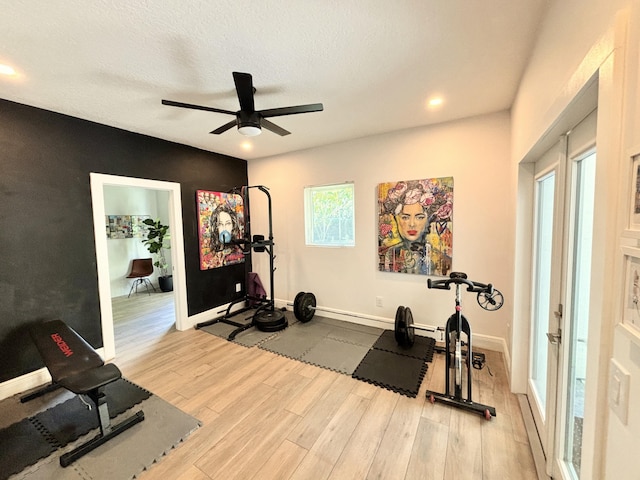 workout room featuring ceiling fan, a textured ceiling, baseboards, and wood finished floors