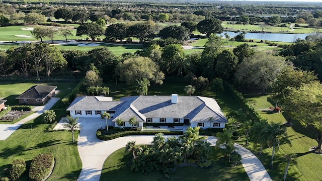 birds eye view of property with golf course view and a water view