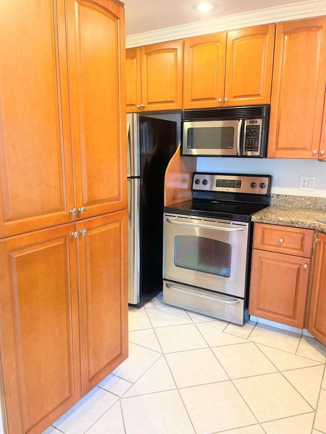 kitchen with light stone counters, appliances with stainless steel finishes, and light tile patterned flooring