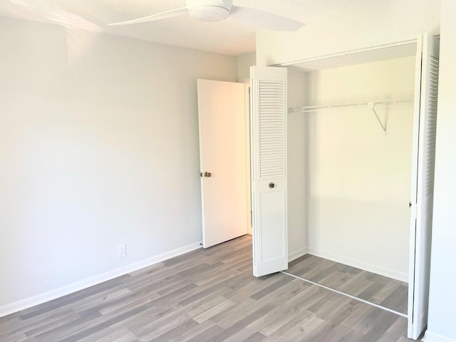 unfurnished bedroom featuring a ceiling fan, baseboards, a closet, and light wood finished floors