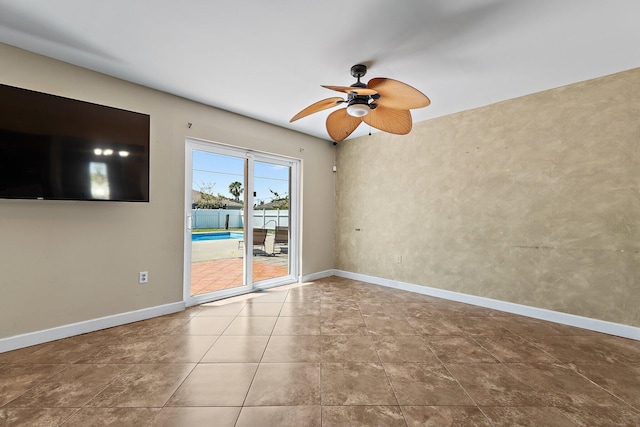 spare room featuring tile patterned flooring, a ceiling fan, and baseboards