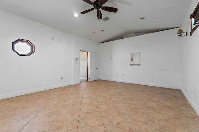 empty room featuring visible vents, baseboards, vaulted ceiling, light tile patterned floors, and a ceiling fan