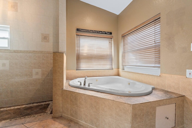 bathroom with tile patterned flooring and a jetted tub