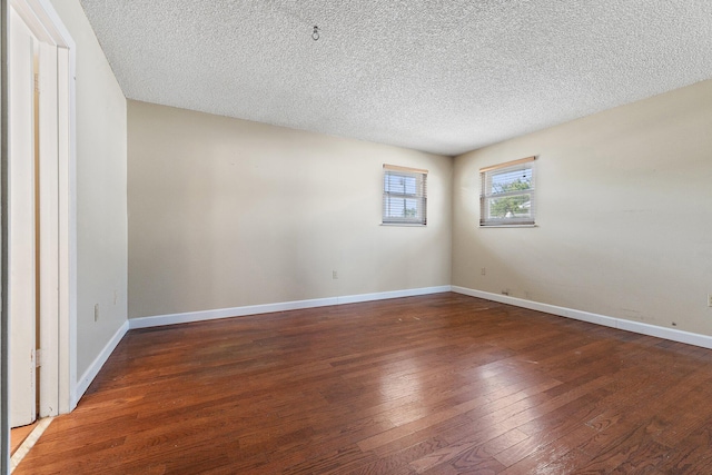 unfurnished room featuring baseboards, wood-type flooring, and a textured ceiling