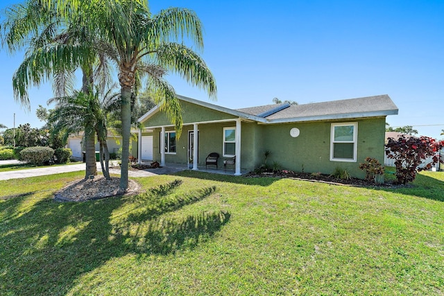 view of front of house with stucco siding, driveway, an attached garage, and a front yard