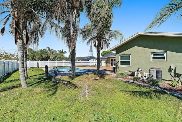 view of yard with central air condition unit, a fenced backyard, and a fenced in pool