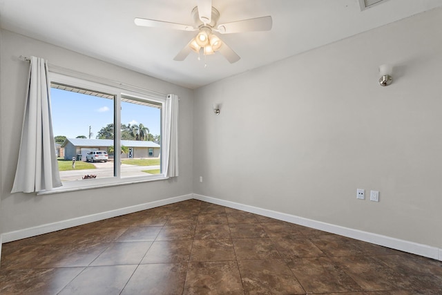 unfurnished room with a ceiling fan and baseboards