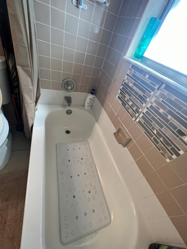 full bath with toilet and shower / tub combo with curtain