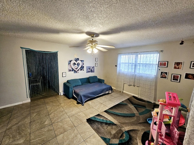 tiled bedroom featuring a textured ceiling, baseboards, and a ceiling fan