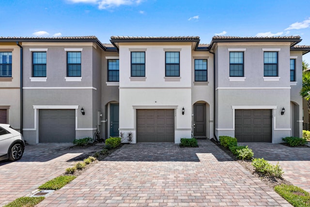 view of property featuring stucco siding and decorative driveway