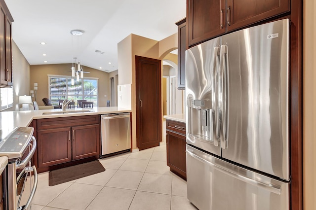 kitchen featuring light tile patterned floors, lofted ceiling, a sink, stainless steel appliances, and light countertops