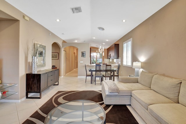 living area featuring visible vents, recessed lighting, arched walkways, light tile patterned flooring, and baseboards