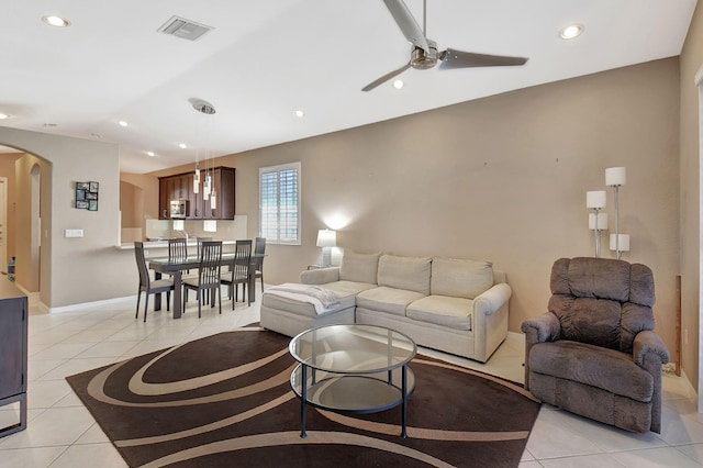 living room with recessed lighting, light tile patterned floors, a ceiling fan, and arched walkways