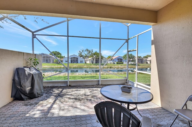 sunroom / solarium featuring a residential view, a water view, and a healthy amount of sunlight