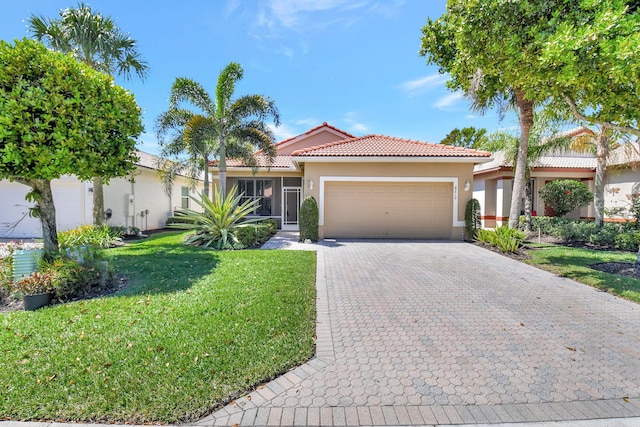 mediterranean / spanish-style house featuring stucco siding, a front lawn, decorative driveway, and a garage