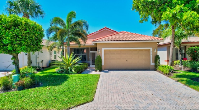 mediterranean / spanish-style house featuring stucco siding, a front lawn, decorative driveway, and a garage