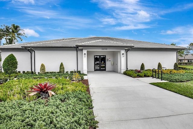 exterior space with stucco siding, driveway, and french doors