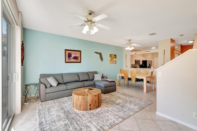 living area with a ceiling fan, light tile patterned floors, baseboards, and visible vents