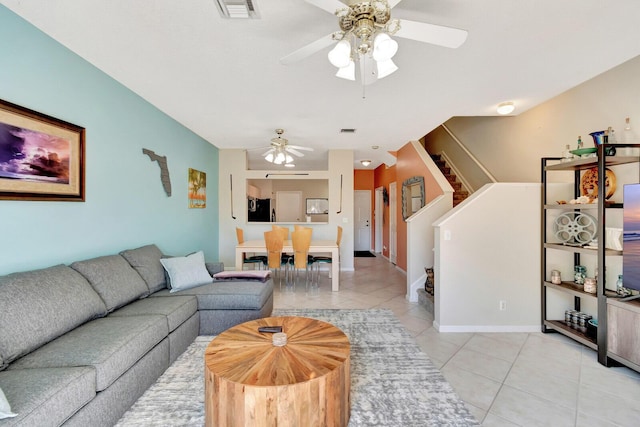 living area featuring stairway, light tile patterned flooring, and visible vents