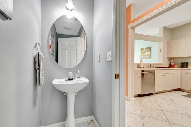 bathroom featuring tile patterned flooring, baseboards, and a sink