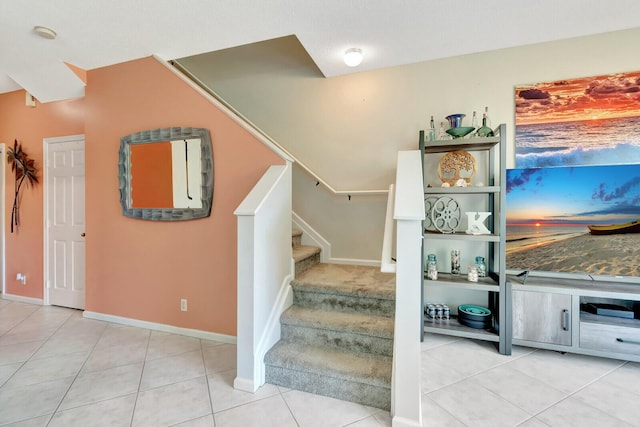 stairway featuring tile patterned floors and baseboards