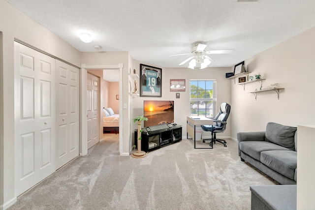 interior space with a ceiling fan, baseboards, and a textured ceiling