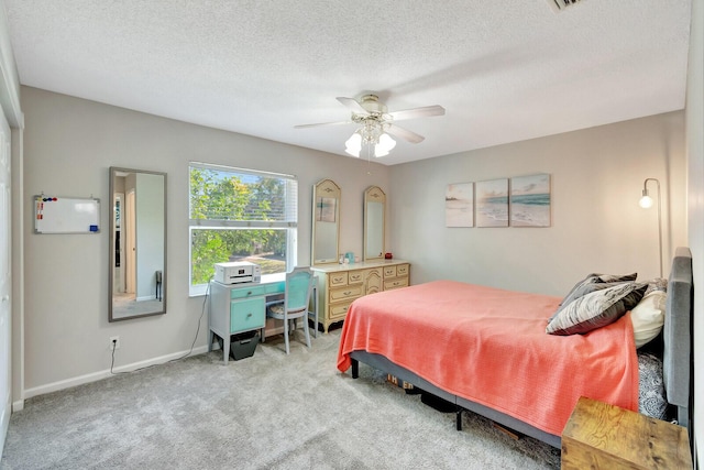 carpeted bedroom with a ceiling fan, baseboards, and a textured ceiling