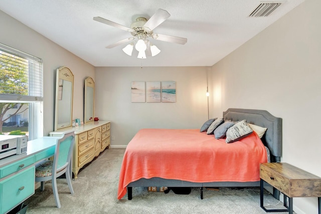 bedroom with a ceiling fan, light colored carpet, visible vents, and baseboards