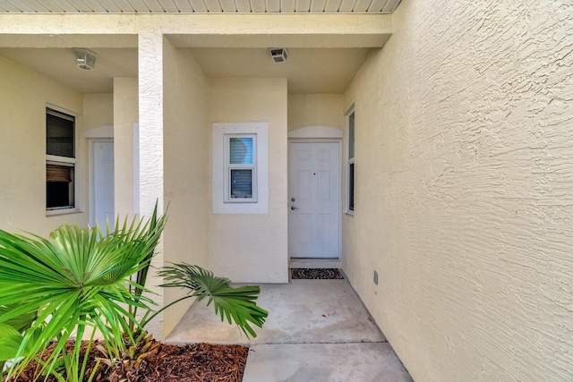 entrance to property featuring stucco siding