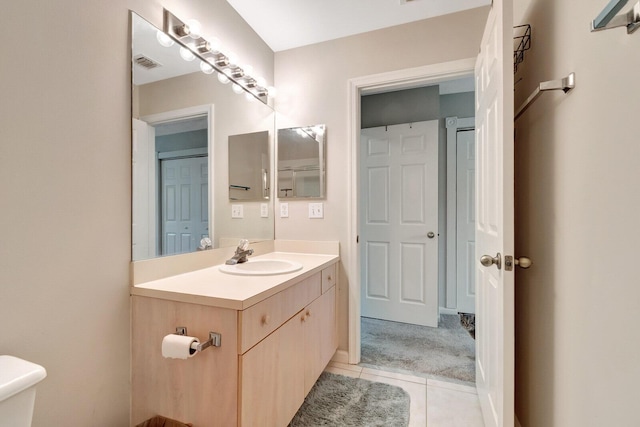 bathroom featuring vanity, toilet, visible vents, and tile patterned flooring