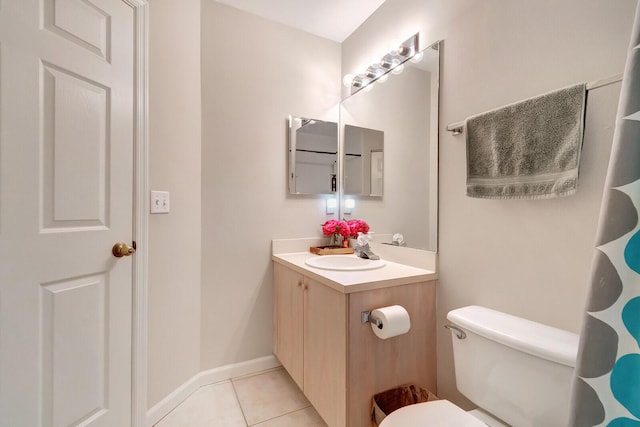 bathroom featuring baseboards, toilet, vanity, and tile patterned flooring