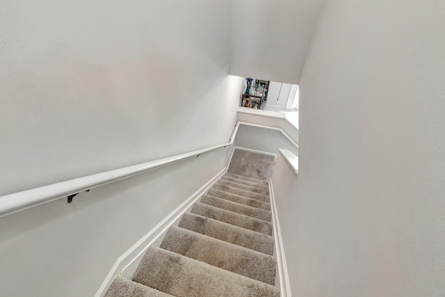 staircase with baseboards and carpet