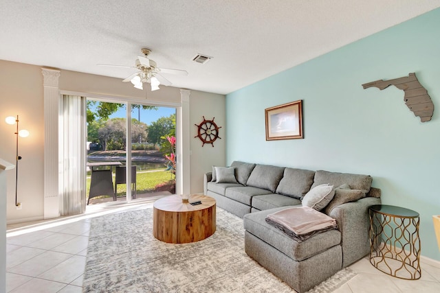 living room with light tile patterned flooring, visible vents, and a textured ceiling