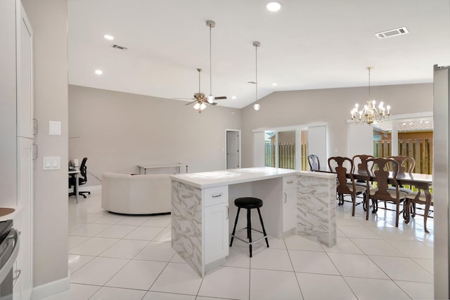 kitchen with lofted ceiling, light tile patterned floors, ceiling fan with notable chandelier, and visible vents