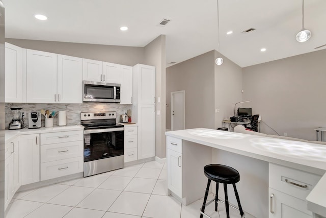 kitchen with backsplash, appliances with stainless steel finishes, light countertops, and white cabinetry