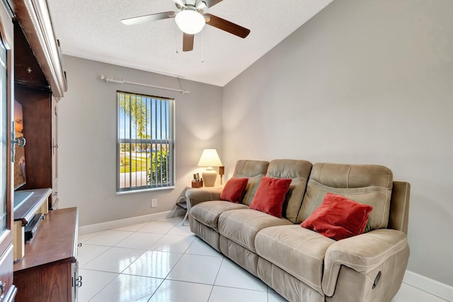 living room with a ceiling fan, baseboards, lofted ceiling, a textured ceiling, and tile patterned floors