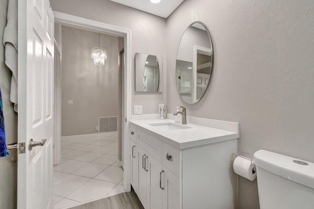 bathroom featuring tile patterned flooring, visible vents, toilet, and vanity