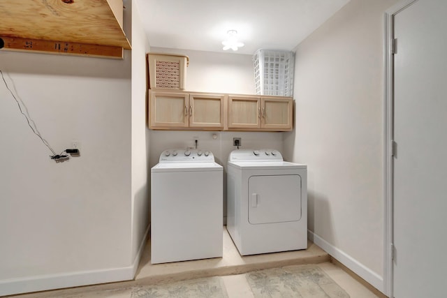 clothes washing area featuring cabinet space, baseboards, and washer and clothes dryer