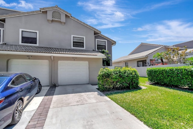 multi unit property with a tiled roof, stucco siding, driveway, and a front yard