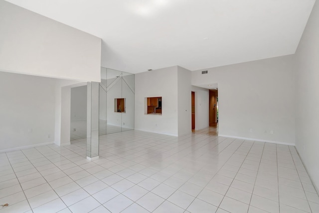 unfurnished living room featuring light tile patterned flooring, baseboards, and visible vents