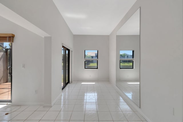 spare room featuring light tile patterned floors and baseboards