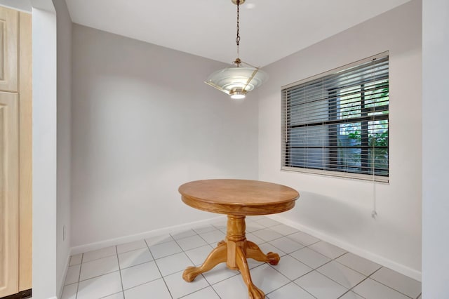 unfurnished dining area featuring light tile patterned flooring and baseboards